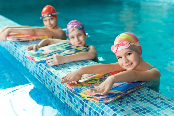 Παιδιά στην πισίνα με σανίδες κατά τη διάρκεια της προπόνησης — Φωτογραφία Αρχείου
