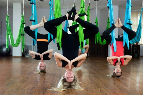 Skupina mladých lidí cvičí jógu na houpací síti ve fitness klubu. Fitness, stretch, rovnováha, cvičení a zdravý životní styl lidí. — Stock fotografie