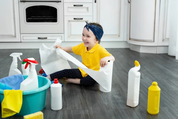 Küçük kız mutfakta kağıt havlularla oynarken temizlik yapıyor. — Stok fotoğraf