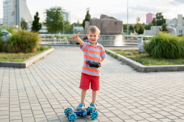Küçük çocuk parkta uzaktan kumandayla oynuyor..