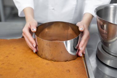 Pasta şefi bisküviden kek kesiyor.