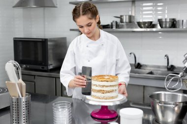 Pasta şefi pastayı kremayla katlıyor..