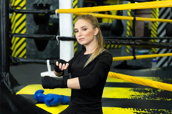 Фото сфокусированной девушки в спортивной форме в боксёрских перчатках во время тренировки. — стоковое фото