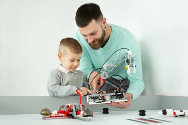 Genç bir baba ve oğul robot kulübünde bir robot yaratıyor.
