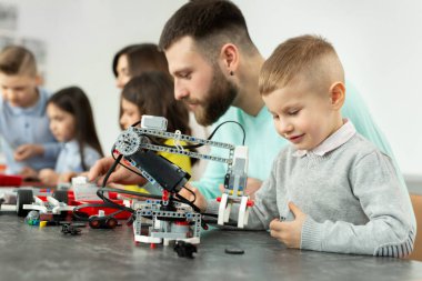 Genç baba ve oğul bir robot okulunda bir inşaat kiti oluşturun.
