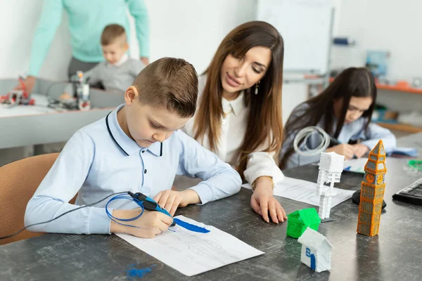 Lesson in the robotics hall. Mom and son use a pen for 3D printing — Stock Photo, Image