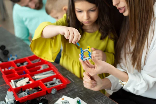 Close-up van een moeder en dochters handen op school maken van een robot bestuurd vanuit een bouwpakket — Stockfoto