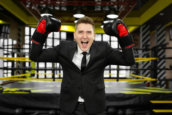 Νεαρός άνδρας επιχειρηματίας με κοστούμι και γάντια πυγμαχίας διασκεδάζει και γελάει. — Φωτογραφία Αρχείου
