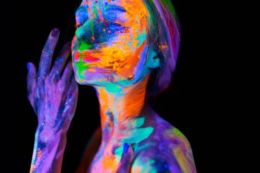 Neon ışıklı güzel bir genç kadın. Renkli makyajlı ve ultraviyole ışıkta poz veren floresan makyajlı bir modelin portresi.
