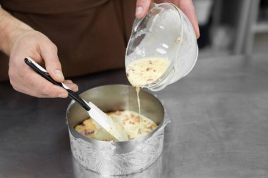 Dişi pasta şeflerinin yakın plan fotoğrafları. Kalıba köpük döküyorlar.