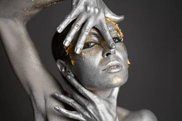 Retrato de una hermosa modelo femenina con pintura dorada y plateada en su piel y cabello en el estudio — Foto de Stock