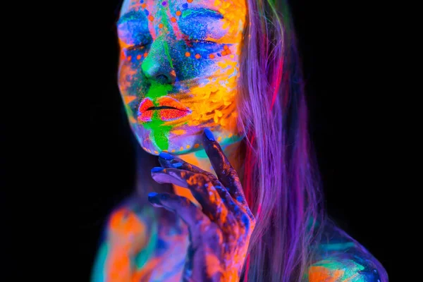 Hermosa joven en luz de neón. Retrato de un modelo con maquillaje fluorescente posando en luz UV con maquillaje colorido. — Foto de Stock