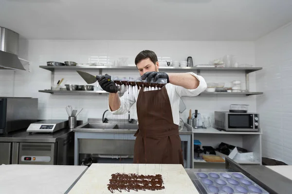 Chef o cioccolatiere fanno cioccolatini dolci in una cucina professionale. — Foto Stock