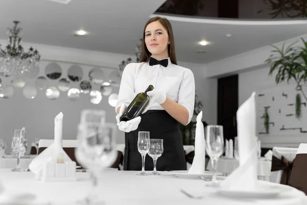 女服务员在餐馆里拿着一瓶酒 — 图库照片