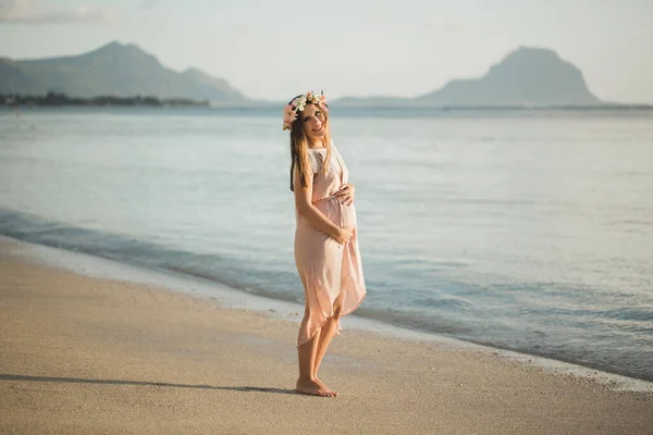 Mujer embarazada en un hermoso vestido en el océano —  Fotos de Stock