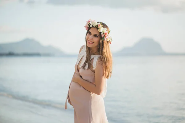 Mujer embarazada en un hermoso vestido en el océano —  Fotos de Stock