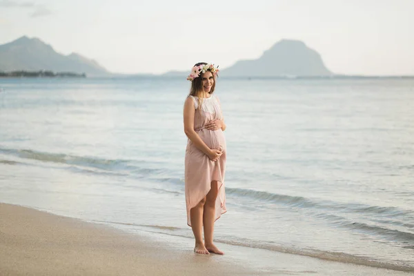 Gravid kvinna i en vacker klänning på havet — Stockfoto