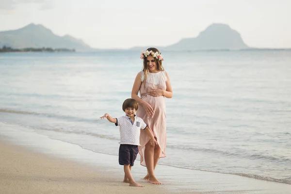 Син і вагітна мама на пляжі — стокове фото