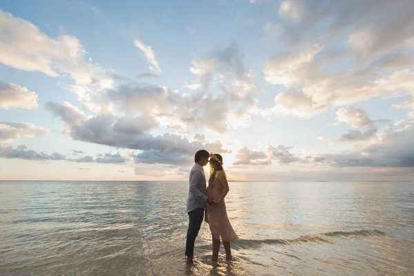 Beautiful pregnant girl and man at sunset. — Stock Photo, Image