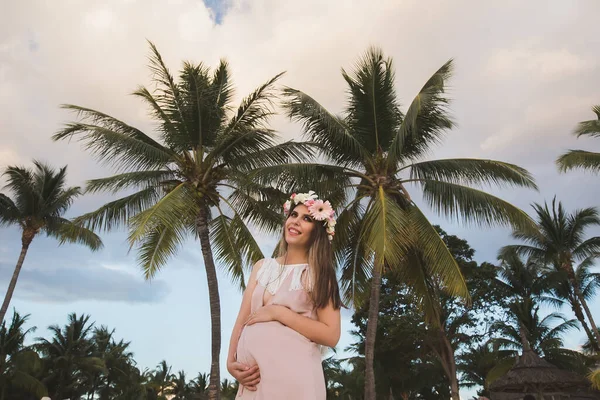 Zwangere vrouw in een prachtige jurk op de oceaan — Stockfoto