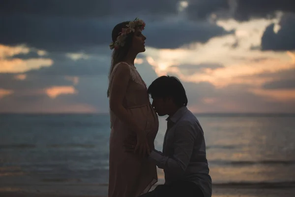 Όμορφη έγκυος κορίτσι και ο άνθρωπος στο ηλιοβασίλεμα. — Φωτογραφία Αρχείου