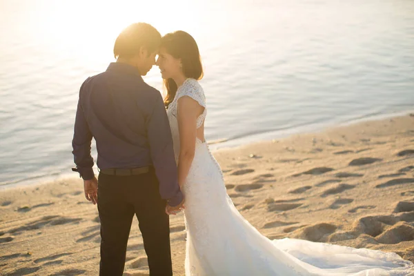 Gelin ve damat sahilde gün batımıyla tanışın.. — Stok fotoğraf