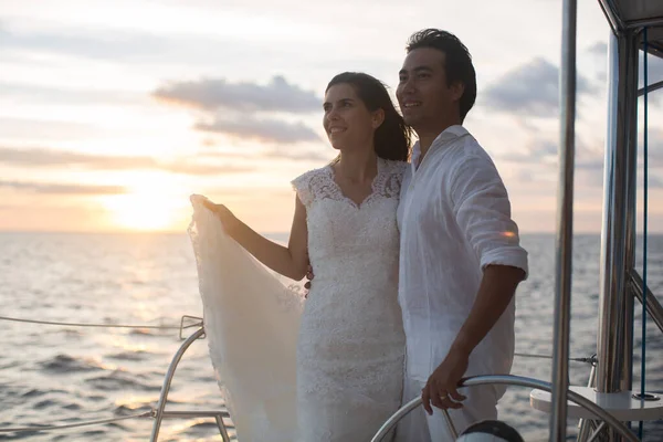 Brudparet på en katamaran. Solnedgången i Indiska oceanen — Stockfoto