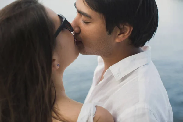 Jeune couple voyage sur un yacht dans l'océan Indien. Homme et femme se tiennent debout sur le bord du bateau et s'embrassent. — Photo