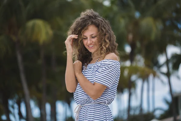 Mooi meisje op een achtergrond van palmbomen. — Stockfoto