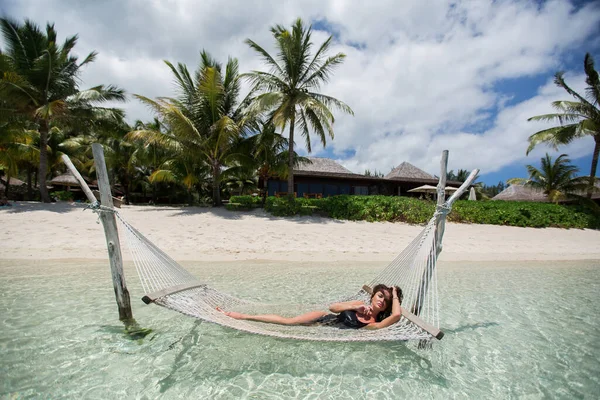 Mulher em rede na praia tropical na ilha . — Fotografia de Stock