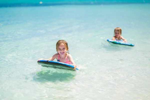Zwillinge Bruder und Schwester haben Spaß beim Surfen im Meer. — Stockfoto