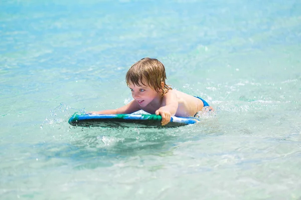 Junger Surfer, glücklicher kleiner Junge im Meer auf dem Surfbrett. — Stockfoto