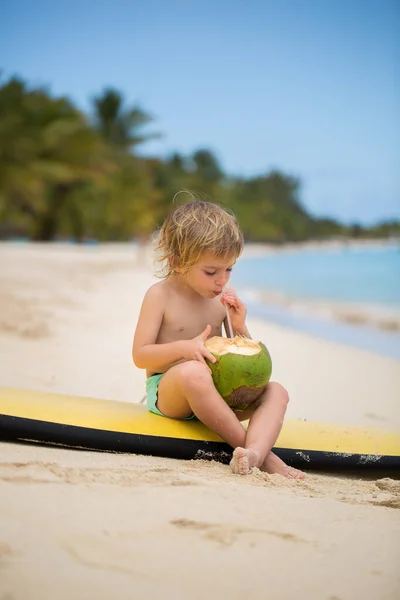 Glücklich lustige kleine Vorschulkind Junge trinkt Kokossaft am Strand — Stockfoto
