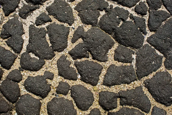 Piedra negra húmeda y arena como telón de fondo — Foto de Stock