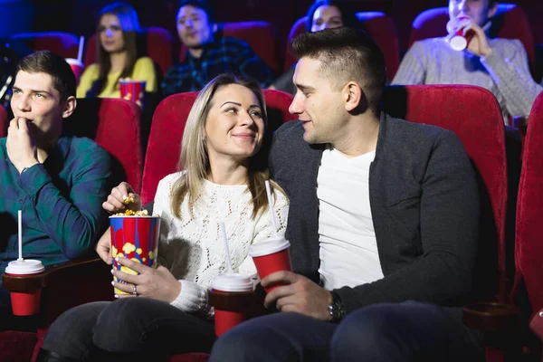 Счастливая молодая пара сидит в кинотеатре и наслаждается просмотром фильма . — стоковое фото