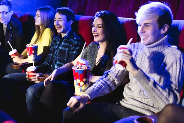 Друзья сидят и едят попкорн вместе во время просмотра фильмов в кинотеатре . — стоковое фото