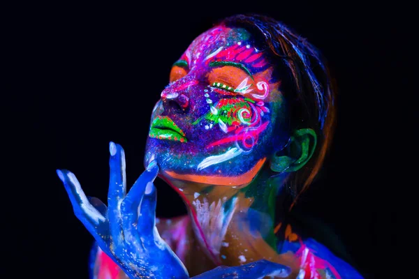 Body art glowing in ultraviolet light. Body art on the body and hand of a girl glowing in the ultraviolet light.