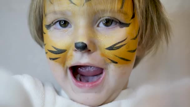 Beautiful young girl with face painted like a tiger — Stock Video