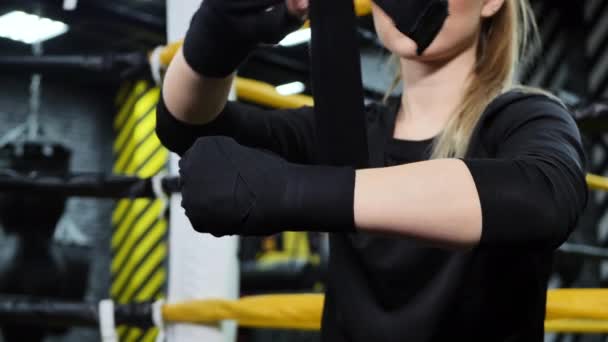 Žena boxer svázat ruce s černým obvazem před tréninkem.