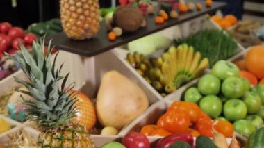 Marketin tezgahında sebze ve meyve dolu ahşap kutu.