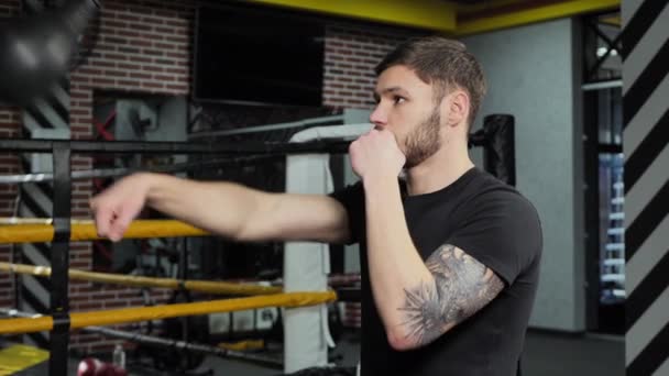 Brutal tattooed boxer who trains in the ring and hits a punching bag — Stock Video