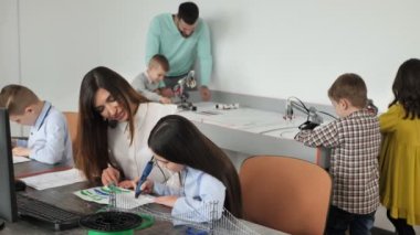 Robotik salonunda ders. 3D yazdırma çizimi, programlanmış robotlarla bir oyun