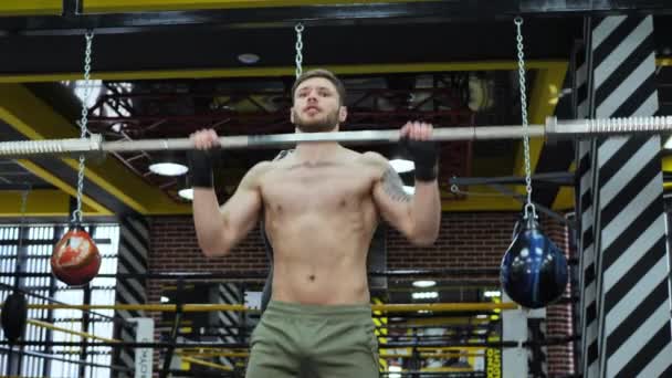 Юный боксёр с голыми грудями тренируется с штангой в боксерском зале — стоковое видео