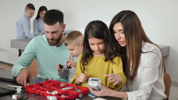 Rodina s dětmi v robotickém klubu dělá robota řízeného konstruktérem — Stock video