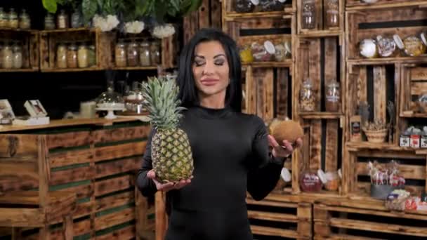 Молодая счастливая женщина держит и продает свежие фрукты в магазине здоровой пищи — стоковое видео