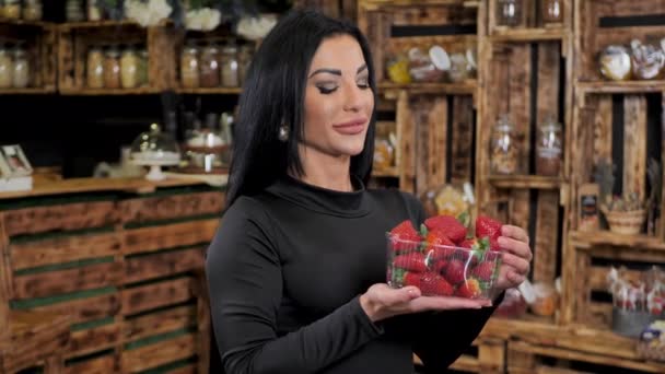 Sexy tânără femeie cu buze de silicon mușcă căpșuni — Videoclip de stoc