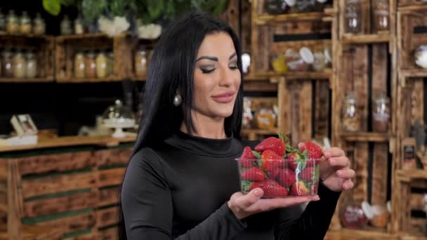 Sexet ung kvinde med silikone læber bider jordbær – Stock-video