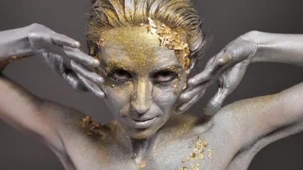 Vacker ung kvinnlig modell med guld och silver färg på hennes hud och hår i studion — Stockvideo