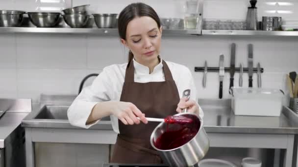 Ženské pečivo šéfkuchař připravuje bobule konfit v hrnci pro plnění dort v profesionální kuchyni — Stock video