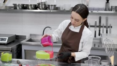 Dişi pasta şefi aynalı pastayla kremalı pasta süsler.